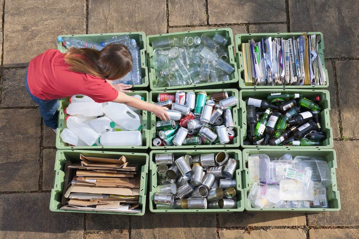 Girl organizing recycling bins Girl organizing recycling bins